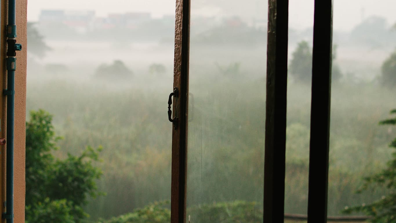 Janela de vidro com moldura de madeira, meio aberta, com paisagem ao fundo, simbolizando as oportunidades da Janela de Johari.