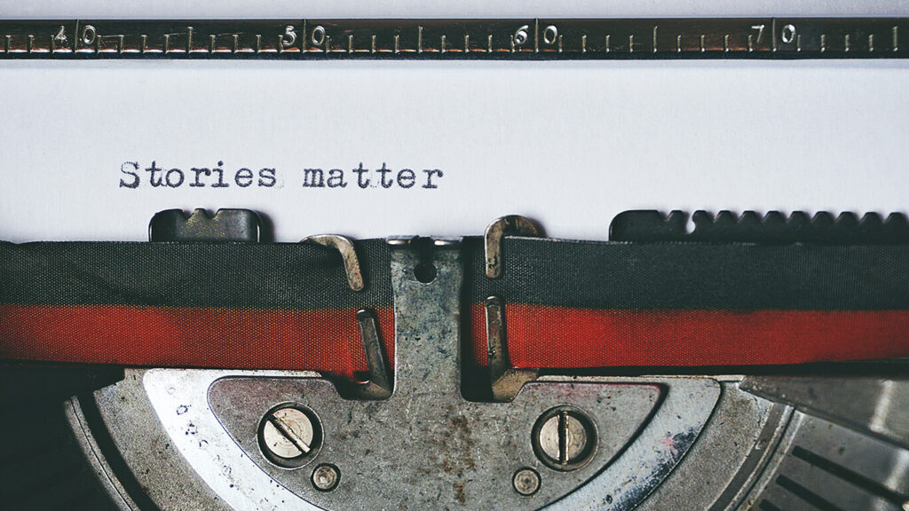 Na foto, uma folha de papel em uma máquina de escrever, onde se lê 'stories matter', ou, em tradução, 'histórias importam', representando a importância de um storytelling para impactar nos resultados.