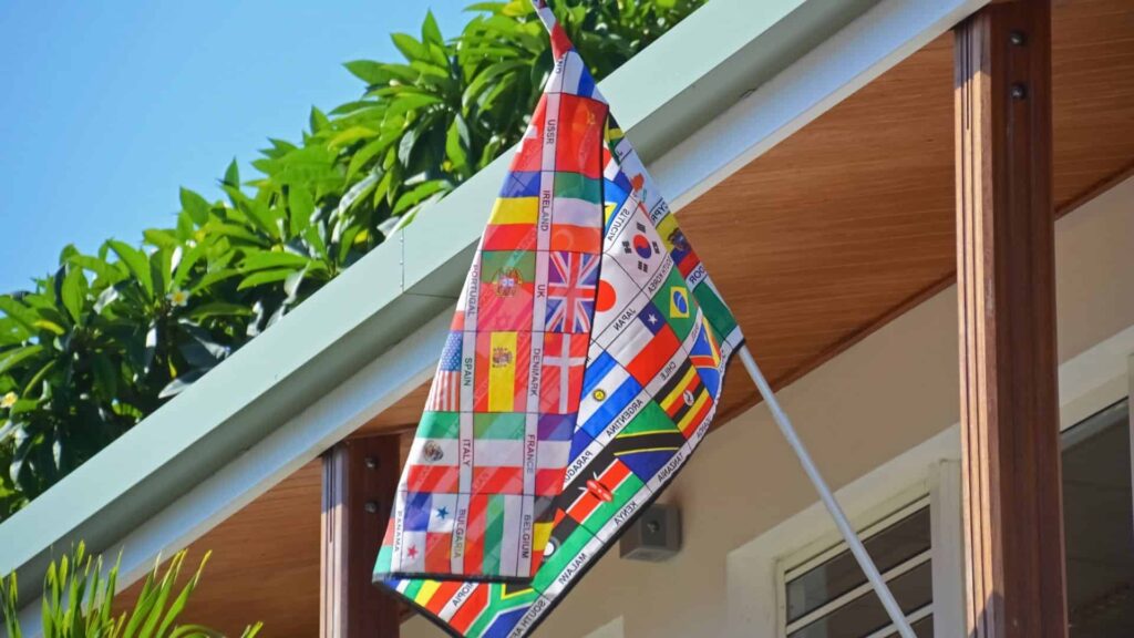 Bandeira pendurada do lado de fora de uma prédio, com as bandeiras de diversos países estampados no pano.