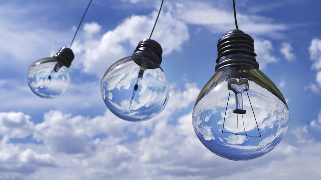 lâmpadas em um cenário de céu azul, representando a relação entre ESG e Gestão