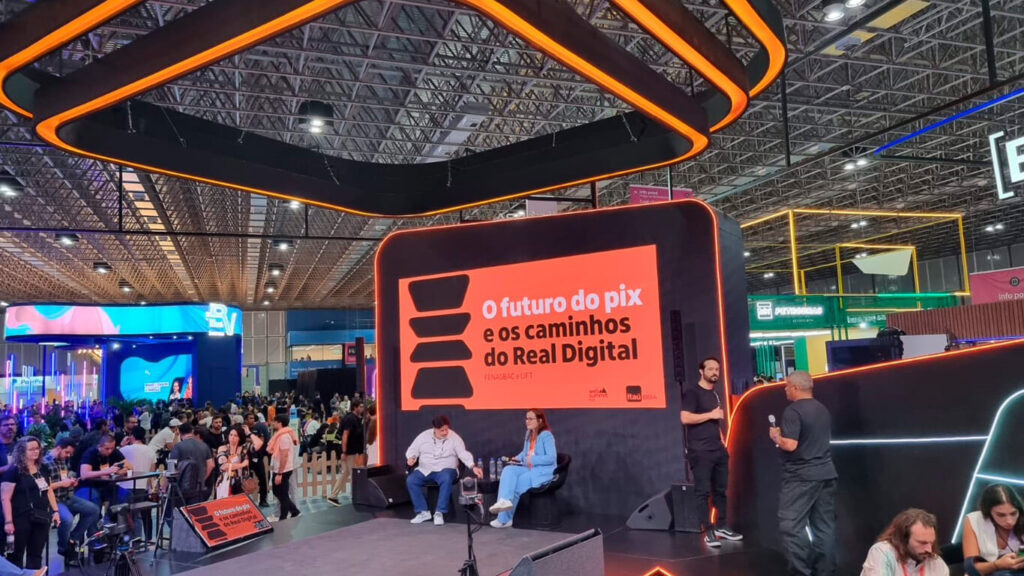 Foto da palestra "O Futuro do PIX e os Caminhos do Real Digital" com o título no telão e pessoas ao redor no Web Summit Rio.