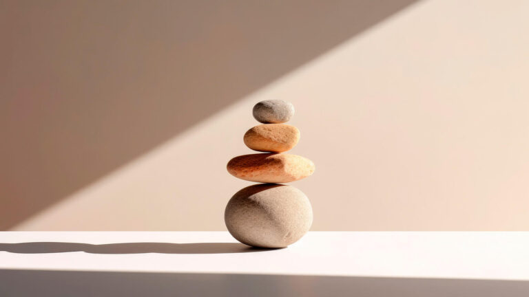Imagem de pedras se equilibrando em relação à pirâmide de maslow, que indica um equilíbrio entre todoas as necessidades humanas.