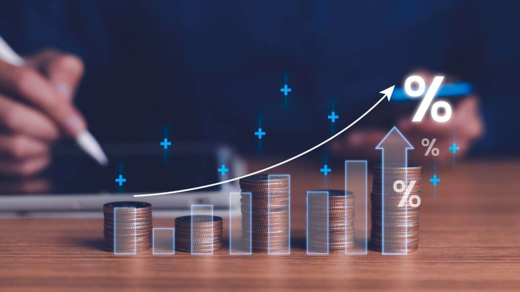 A imagem ilustra a avaliação de ações, destacando o crescimento financeiro com pilhas de moedas e gráficos ascendentes. Percentuais no gráfico sugerem aumentos percentuais, enquanto uma pessoa interage com uma tela, possivelmente analisando dados. A cena transmite a ideia de evolução no mercado financeiro e a importância da avaliação no processo de investimento.
