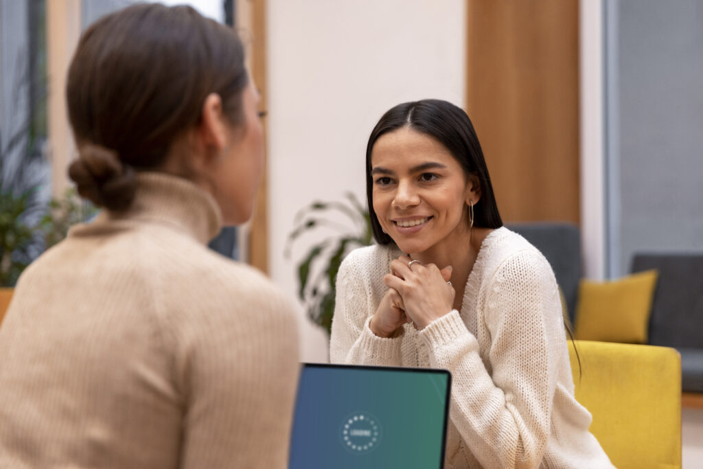Duas mulheres em uma conversa tranquila e envolvente, sugerindo uma troca de ideias produtiva.