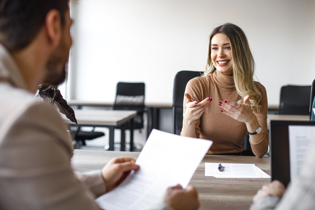 Homem e mulher conversando durante negociação de salário em entrevista de emprego.