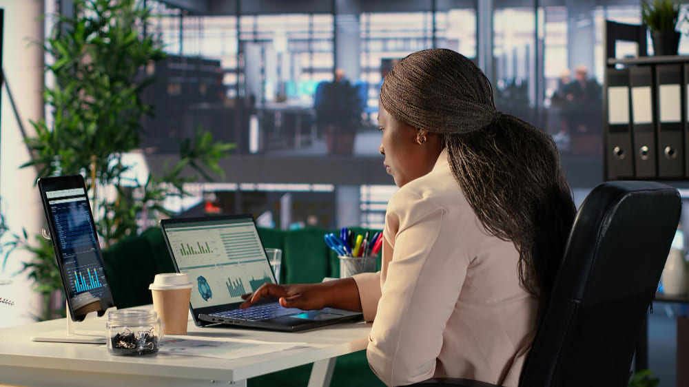 Profissional do setor financeiro analisando indicadores, aprofundando conhecimentos estratégicos durante um MBA para bancários.